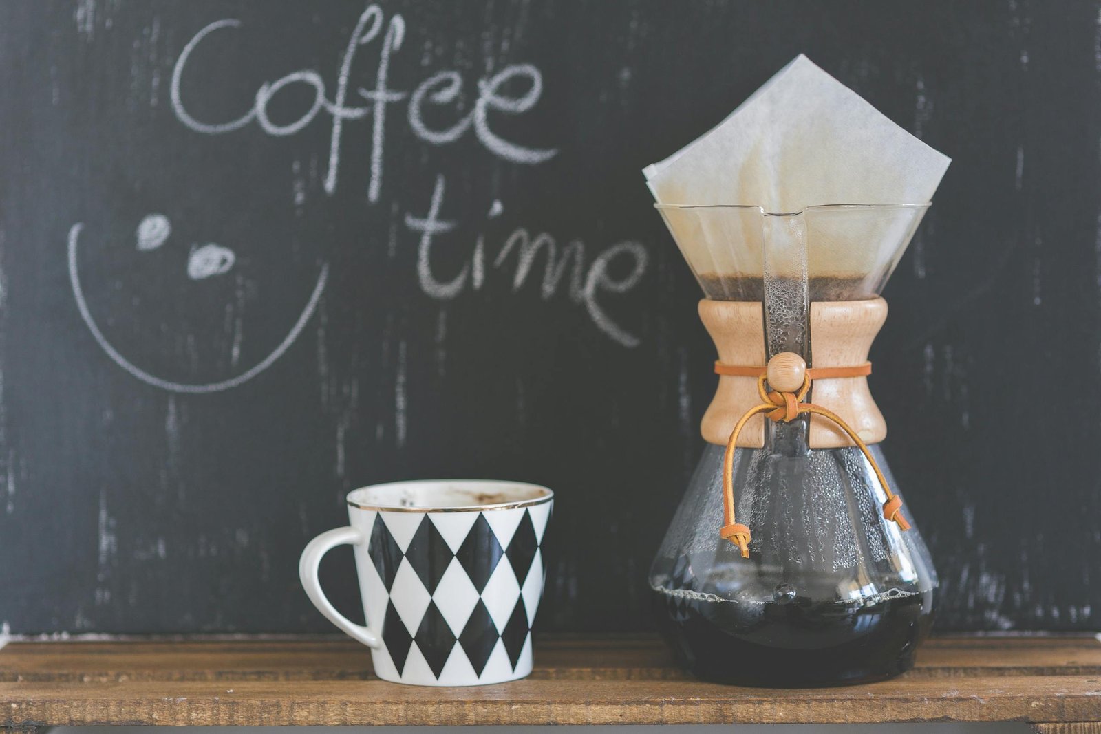 A cozy café scene featuring a Chemex with freshly brewed coffee and a patterned mug, perfect for morning rituals.